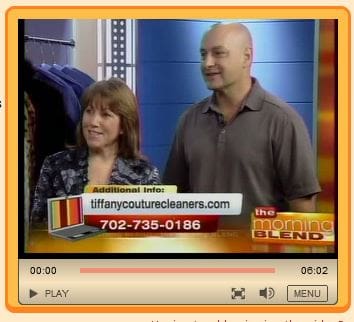 Two people stand in a TV studio with a "tiffanycouturecleaners.com" banner and contact number displayed on the screen during a segment of "The Morning Blend" show.